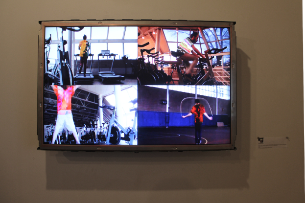 Ein an der Wand montierter Fernseher mit Menschen, die Sport treiben.