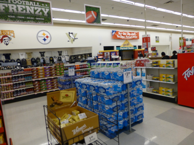 Eine Einkaufszentrumsauslage mit verschiedenen Artikeln, einschließlich Lampen und Postern auf Gestellen.