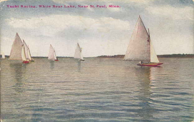 Eine Gruppe von Segelbooten auf einem Gewässer mit Bäumen im Hintergrund und einem klaren blauen Himmel, Text oben lautet "Segelregatta, White Bear Lake, Near St. Paul, Minnesota".