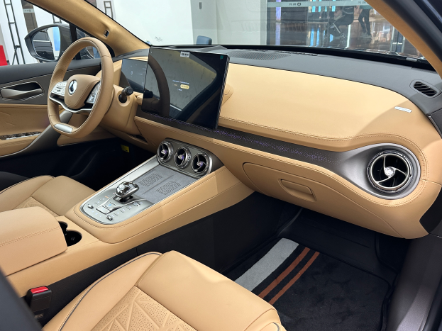 Das Innere eines Mercedes-Benz S-Klasse Limousinen auf der IAA in Frankfurt, mit Lenkrad, Armaturenbrett, Bildschirmen, Knöpfen, Sitzen, Außenspiegeln und Glasfenstern, durch die Menschen, Gebäude und andere Gegenstände im Hintergrund zu sehen sind.