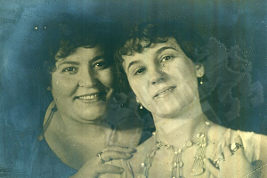 Zwei Frauen lächeln warm in einem alten Foto, ihre Augen strahlen vor Leben.