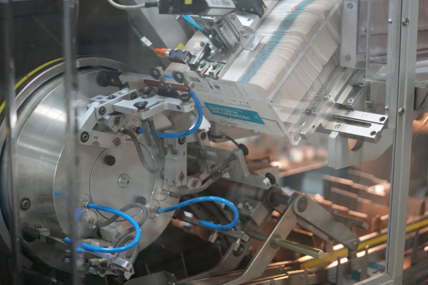 Automatisiertes Verpackungssystem auf einem Fabriktor mit unscharfen Hintergrundkomponenten.