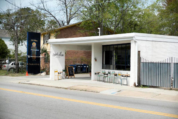 Ein Restaurant entlang einer Straße mit Bäumen im Hintergrund.