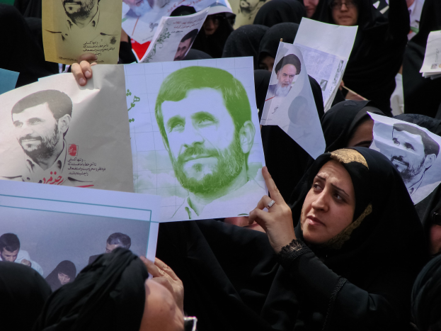 Eine Gruppe iranischer Frauen in schwarzer Kleidung, einige mit Brille, halten Bilder des Präsidenten Mahmoud Ahmadinejad während einer Demonstration in Tehran hoch.