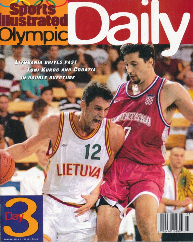 Magazinumschlag mit zwei M├Ąnnern, die Basketball spielen, mit einer Gruppe von Menschen im Hintergrund, Text lautet "Sports Illustrated Olympic Daily".