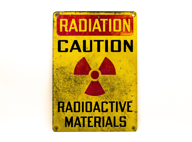 Gelbes Warnschild mit fetter schwarzer Schrift "Strahlungswarnung" und einem radioaktiven Symbol auf einem weißen Hintergrund.