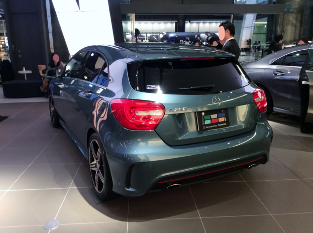 Ein Mercedes-Benz A-Klasse Schrägheck in Frankfurt, ein schlankes, modernes Design mit einer glänzenden schwarzen Lackierung und Chromakzenten, umgeben von einer Gruppe von Menschen.