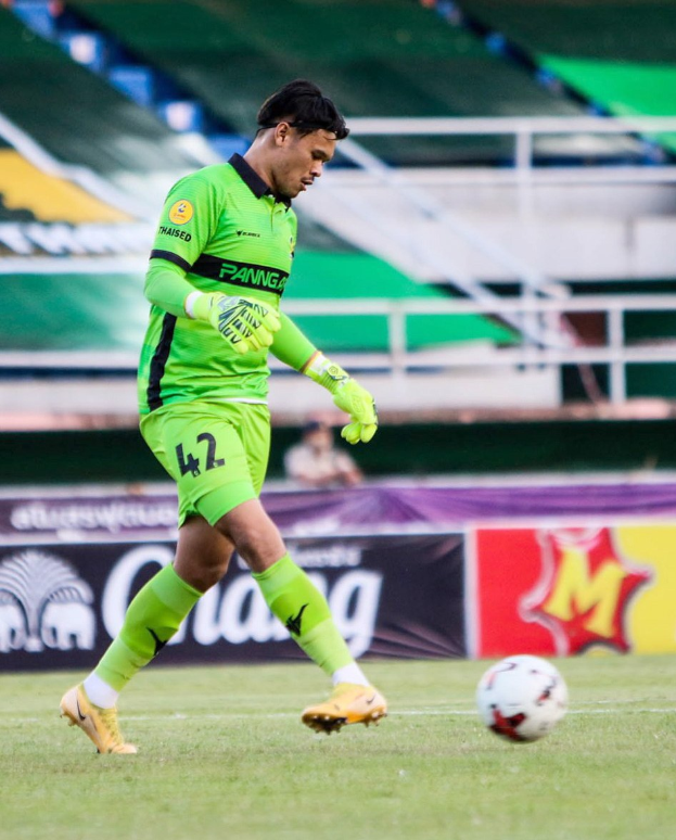 Ein Torwart in grüner Uniform kickt einen Fußball auf einem Rasenfeld während eines Spiels zwischen Chivas USA und Mexico City in der Copa Libertadores, wie es durch Banner im Hintergrund angezeigt wird.