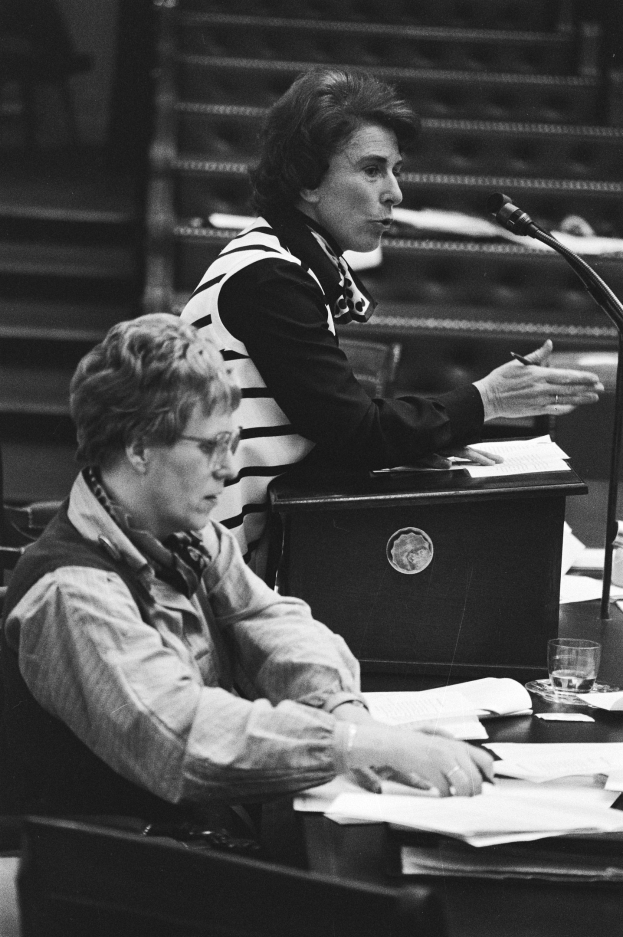 Frau sitzt an einem Tisch vor einem Mikrofon im Europäischen Parlament in Straßburg, Mai 1981, hält einen Stift mit Papieren, ein Wasserglas und andere Gegenstände auf dem Tisch, schwarz-weißes Bild.