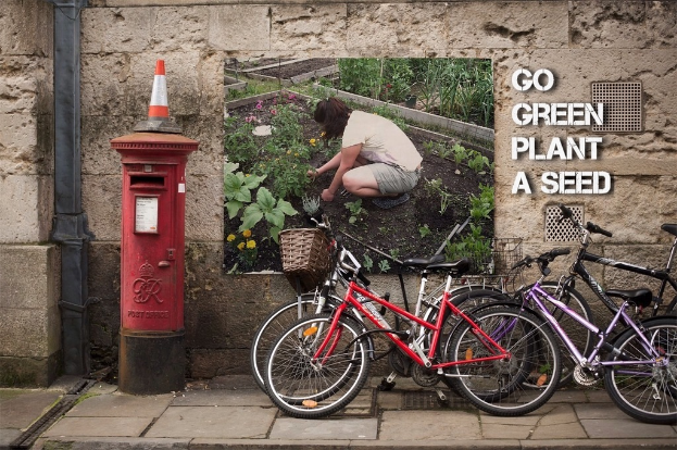 Fahrräder sind in der Nähe eines Briefkastens mit einem Sicherheitstonnen darauf geparkt, mit einem Plakat an einer Wand im Hintergrund und einem Weg am unteren Rand des Bildes.