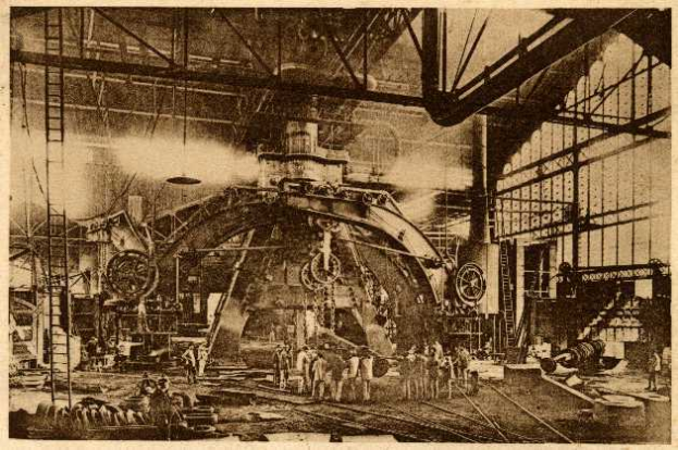 Ein Schwarz-Weiß-Foto einer Fabrikszene bei Cadillac Steel Works, das Menschen bei der Bedienung einer großen Maschine zeigt, umgeben von Leitern, Stangen und anderem Equipment.