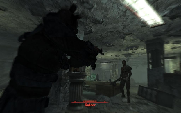 Das Innere eines Geb├Ąudes mit Skulpturen, einer Leuchte und einem gerahmten Kunstwerk an der Wand.