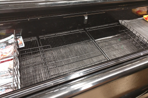 Kühlschrank mit einem Metallgestell mit Lebensmittelpackungen und anderen Gegenständen.